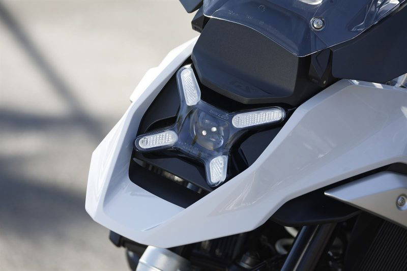 Netradičný tvar predného svetlometu zaručuje, že nový model BMW R 1300 GS si isto s ničím nepomýlite. Červené pole otáčok sa na digitálnej prístrojovej doske pohybuje podľa toho, ako sa zahraje motor. Na ľavú rukoväť pribudli aj nové ovládače, dozadu snímač vozidiel za vami